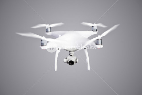 Flying Helicopter Drone With Rised Landing Gears And Camera. Studio Shot On Gray Background.