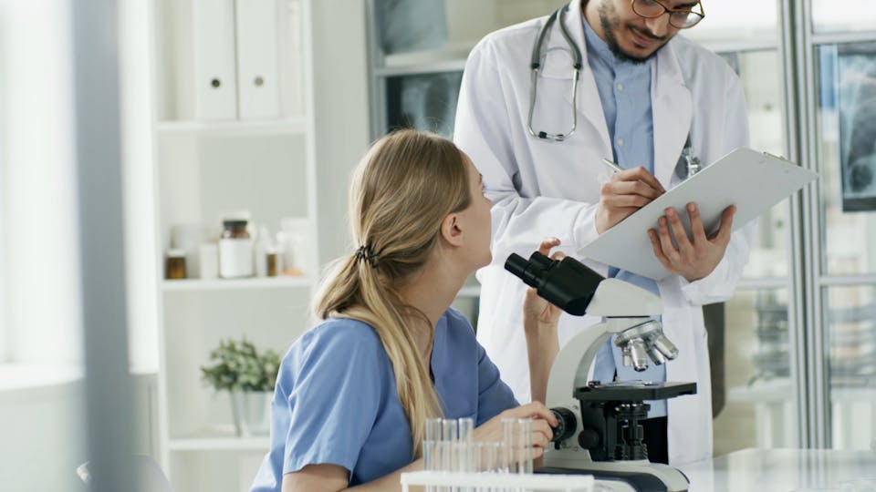 Woman Looking At A Microscope