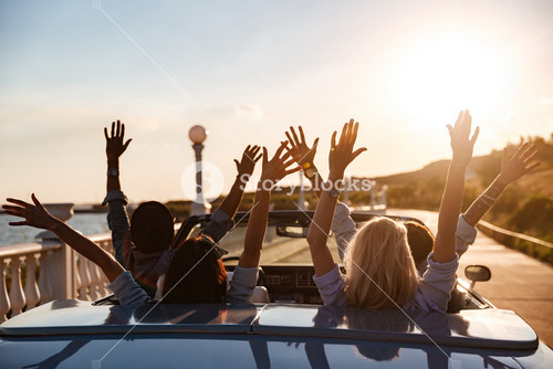 Friends Enjoying Sunset Drive In A Convertible