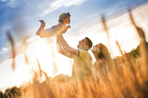 Joyful Family Enjoying Time Together In Sunny Field