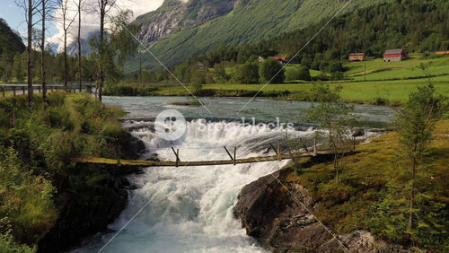 Suspension Bridge Over The Mountain River. Beautiful Nature Norway Natural Landscape.